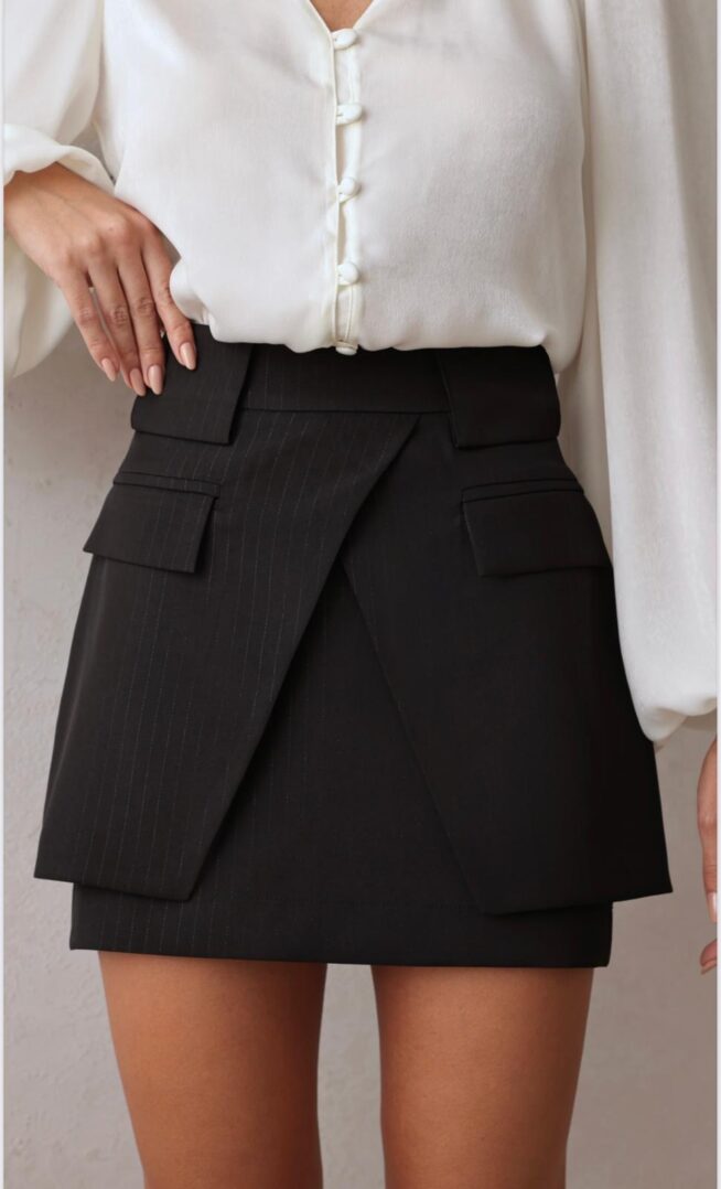 Woman wearing white blouse and black skirt.