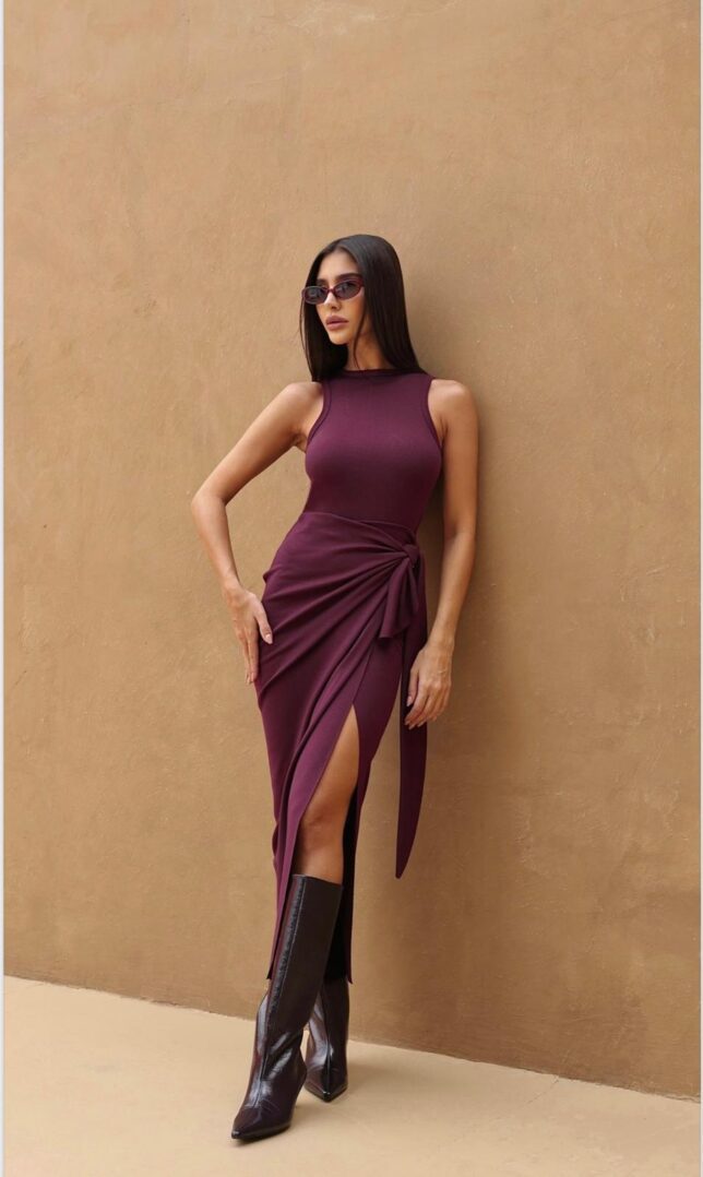 Woman in burgundy dress and boots.