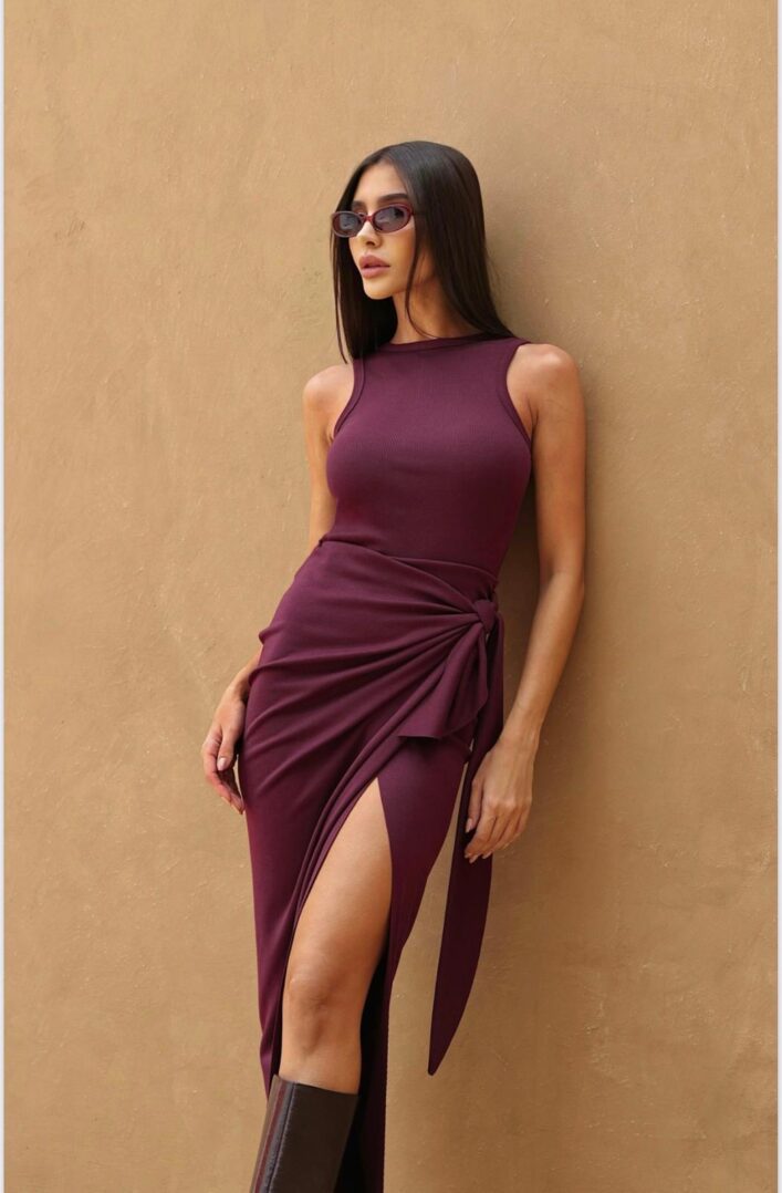 Woman in burgundy dress and sunglasses.