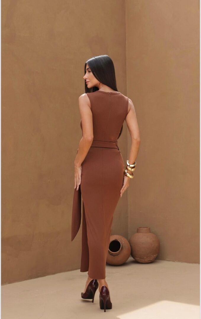 Woman in brown dress, standing, side view.