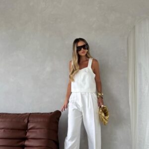 Woman in white outfit with sunglasses.