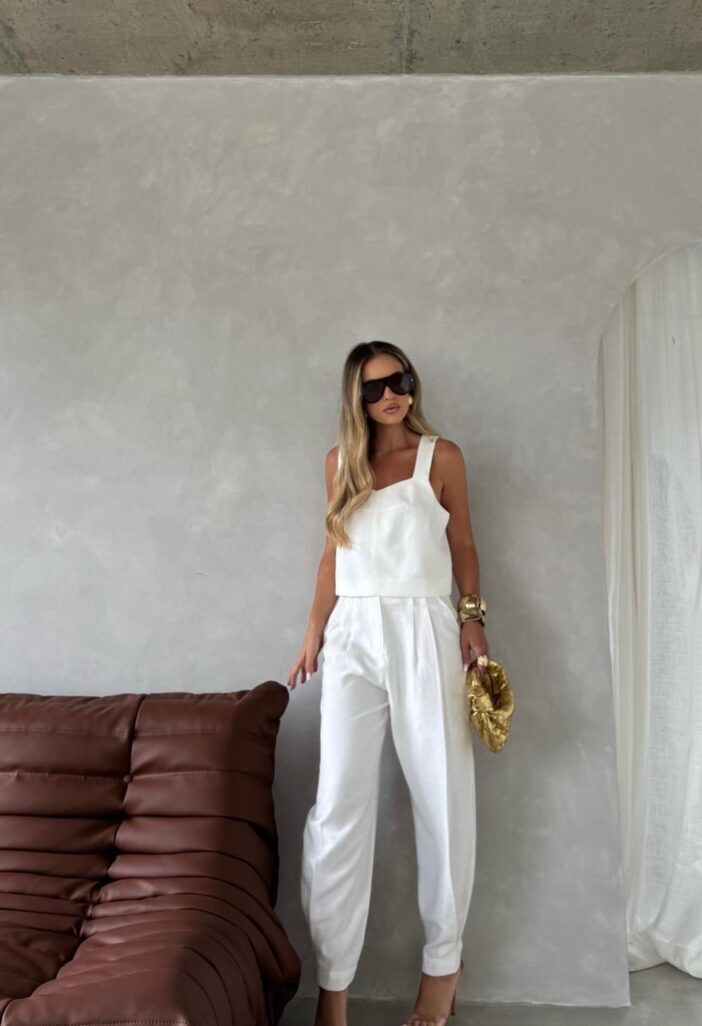 Woman in white outfit with sunglasses.
